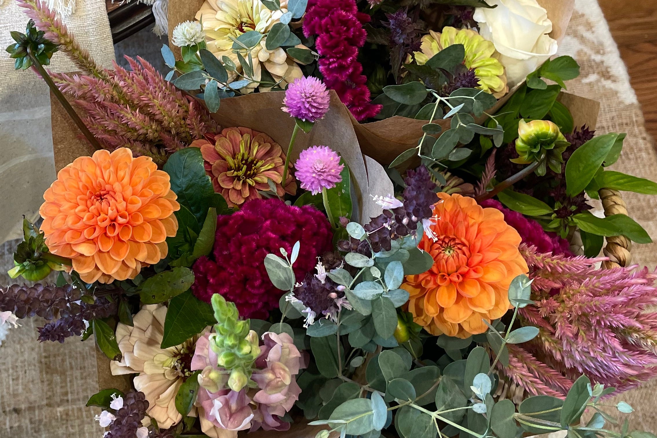 Colorful bouquet of flowers on a textured surface with a wooden floor in the background