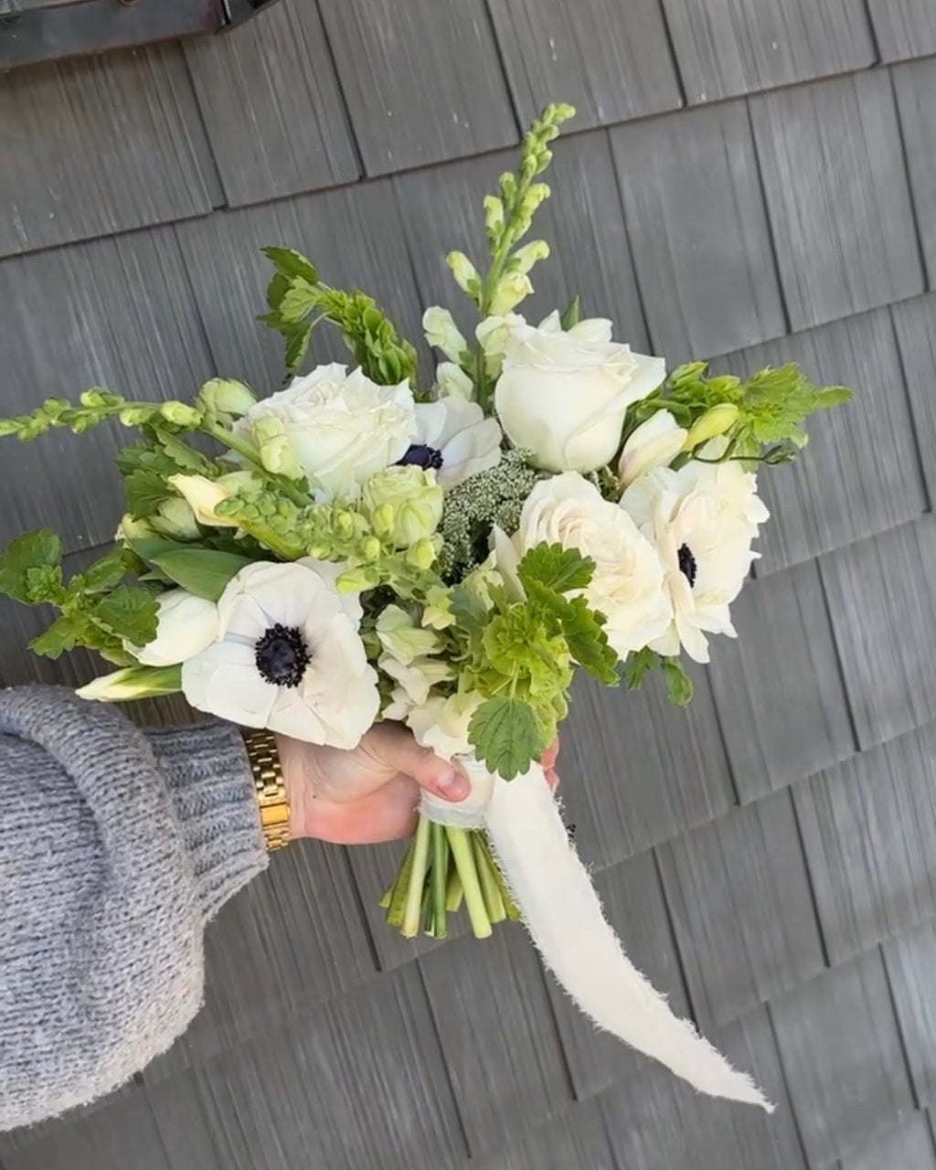Bouquet of flowers held by a person on a wooden deck